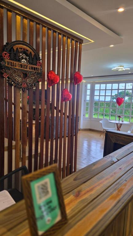 een tafel met rode bloemen die aan een muur hangen bij Pousada Villa Dolce Amore - Boutique Hotel in Campos do Jordão