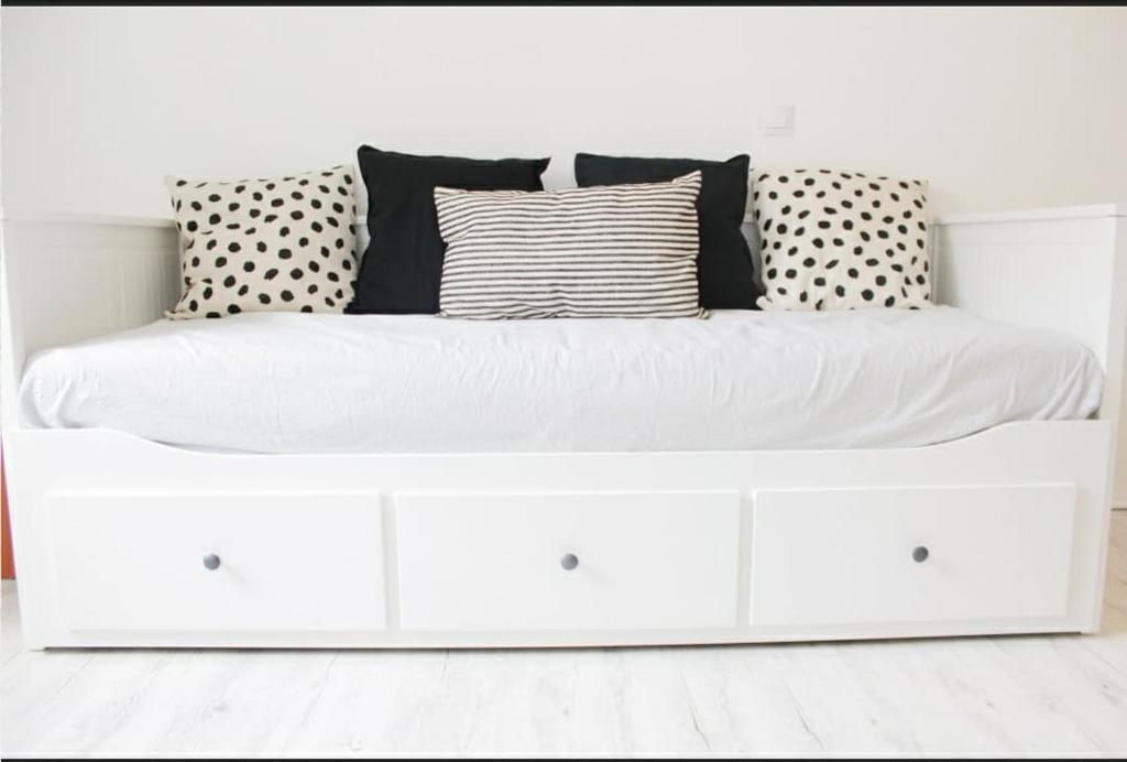 a white bed with pillows on it in a room at Studio-parking-wifi-Disney-Val d'Europe 10 mn in Montévrain