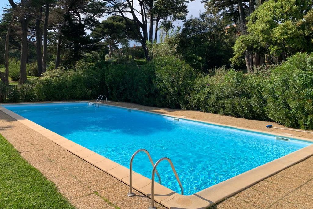 une grande piscine bleue dans une cour dans l'établissement Villa 5 rooms with pool near the sea, à Hyères