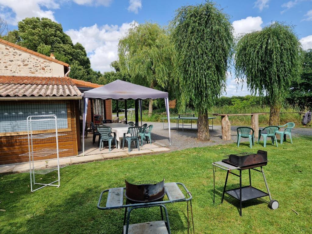 une cour arrière avec un barbecue et un gazebo dans l'établissement Gite villa Diana piscine, à La Celle-sous-Gouzon
