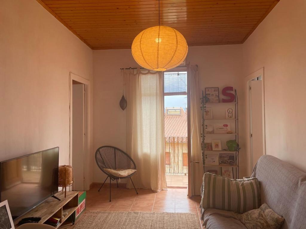 Una sala de estar con un sofá y un televisor. en El Racó de Baix, en Seva
