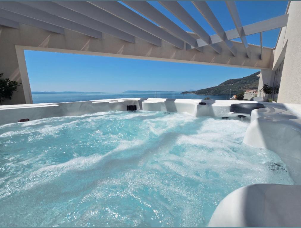 a jacuzzi tub with a view of the ocean at Penthouse Villa Soll in Drasnice