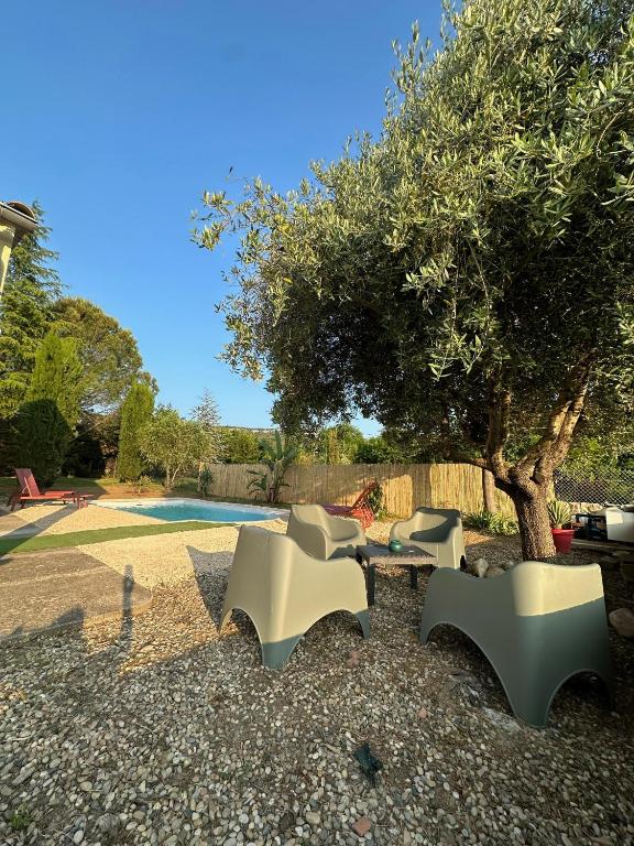 a group of benches sitting next to a tree at La Maison du Bourboul in Grospierres
