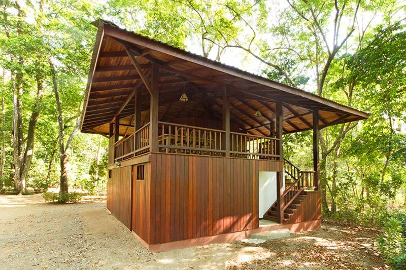 ein kleines Holzgebäude mit einer Terrasse im Wald in der Unterkunft Pieza Paraíso in Cabo Matapalo