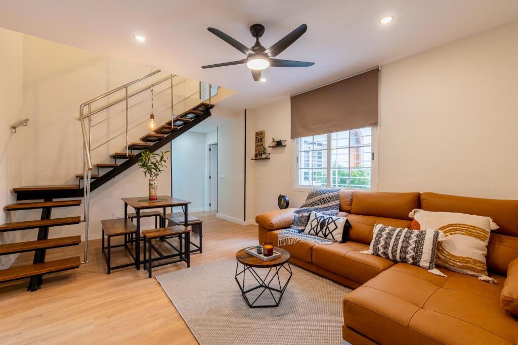 a living room with a couch and a staircase at Céntrico y amplio apartamento in Seville