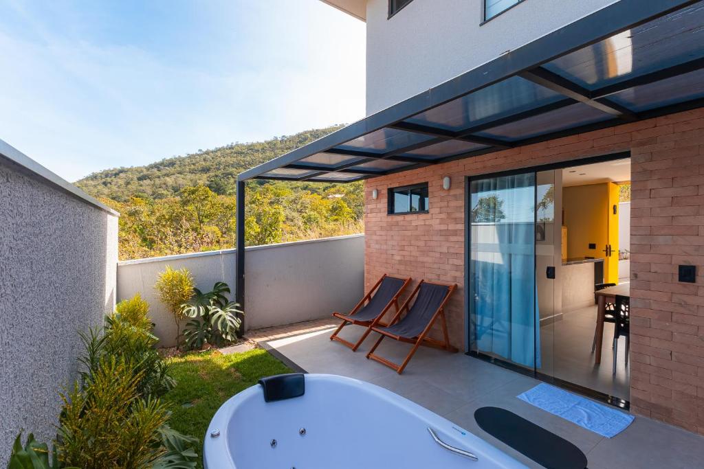 a house with a tub on a balcony at Linda casa no condomínio Piri Living in Pirenópolis