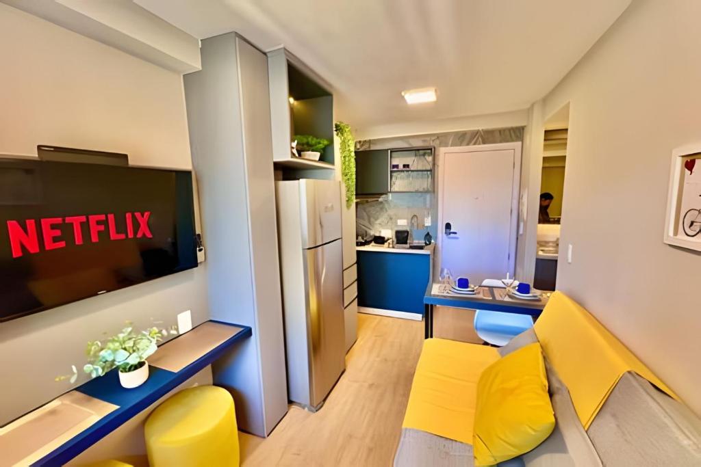 a living room with yellow chairs and a kitchen at O fenômeno, Apto nobre in Curitiba