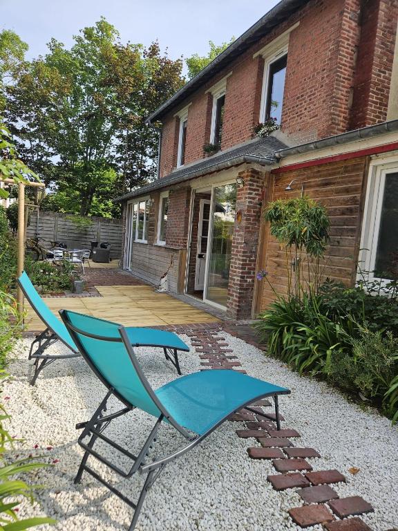 une chaise bleue assise devant une maison dans l'établissement Mongaiséjour, à Tourgéville