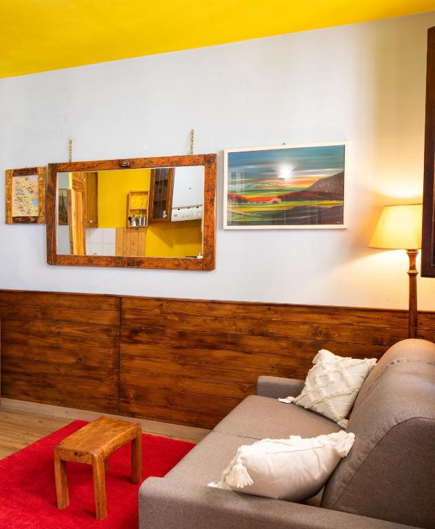 a living room with a couch and a mirror at la porta di destra in Foiano della Chiana