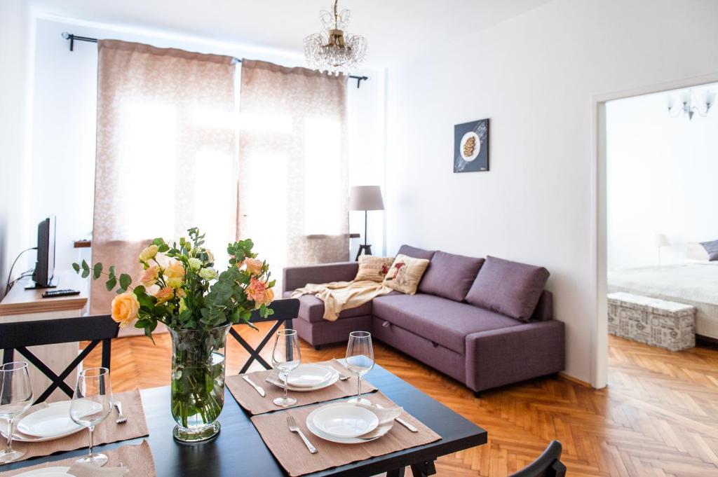 プラハにあるStunning Design Apartmentのリビングルーム(ソファ、花のテーブル付)