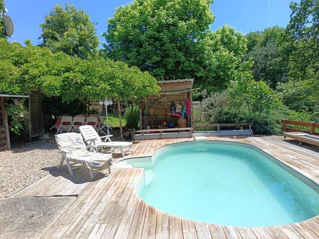 - une piscine sur une terrasse en bois avec une table et des chaises dans l'établissement Mas Picou, à La Force