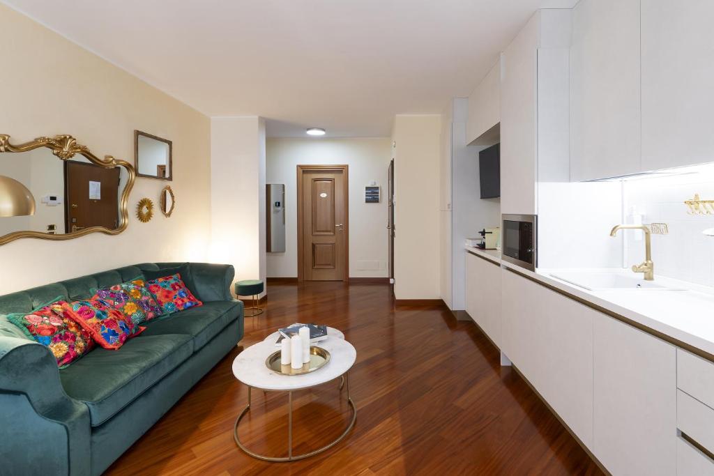Una sala de estar con un sofá verde y una mesa. en Ca' forte residence, en Venecia