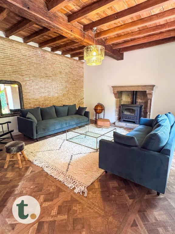 un salon avec deux canapés et une cheminée dans l'établissement Tranquiloue - Maison de Campagne Proche Puy du Fou, à Tiffauges