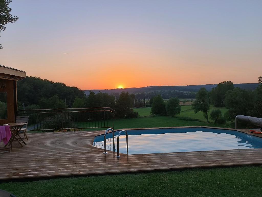une piscine sur une terrasse avec un coucher de soleil en arrière-plan dans l'établissement Maison de campagne, à Castelnau-de-Montmiral