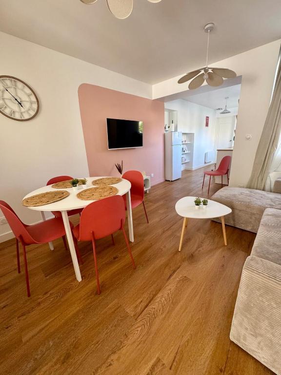 un salon avec une table, des chaises et un canapé dans l'établissement Les Chouettes, au Mans