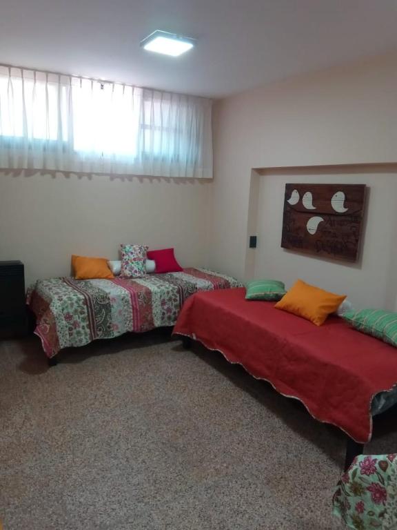 a room with two beds and a window at El Departamentito in Villa Mercedes