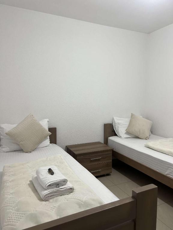 two beds with towels on them in a room at Hotel Palace Struga in Struga