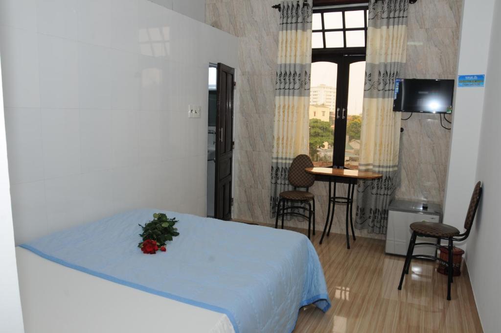 Un dormitorio con una cama con una flor. en Bien Khoi Mini Hotel en Hue