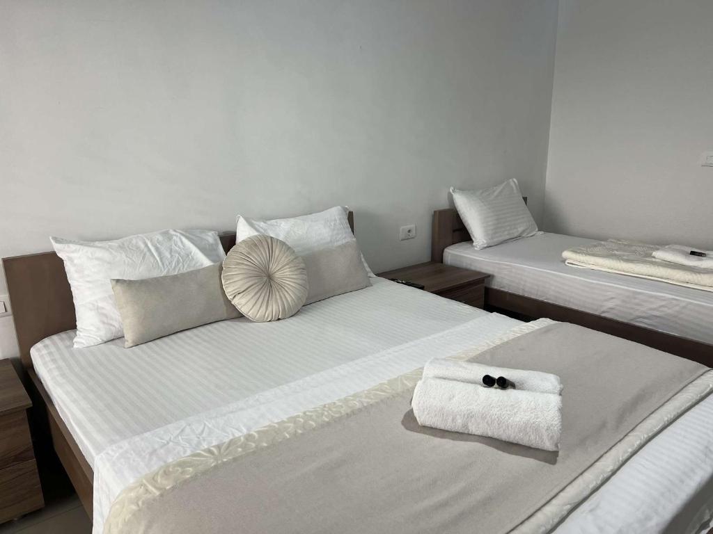 two beds in a room with towels on them at Hotel Palace Struga in Struga