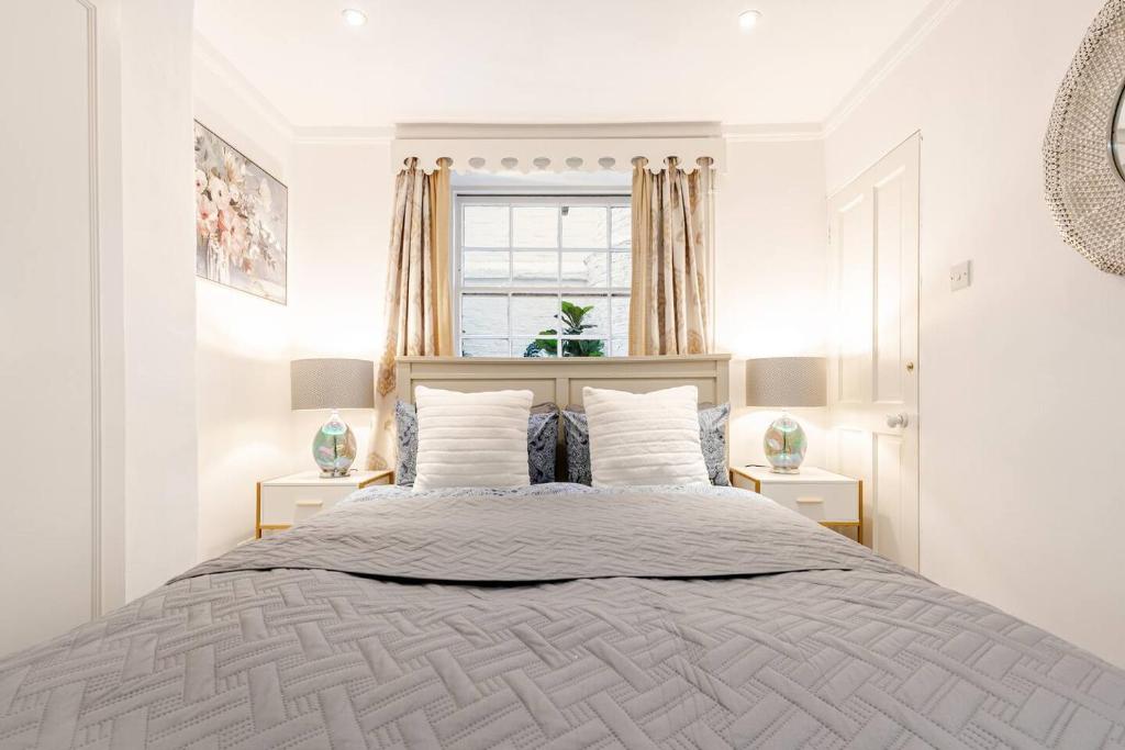 a white bedroom with a large bed and a window at Grand Design Deluxe Suite by Buckingham Palace in London