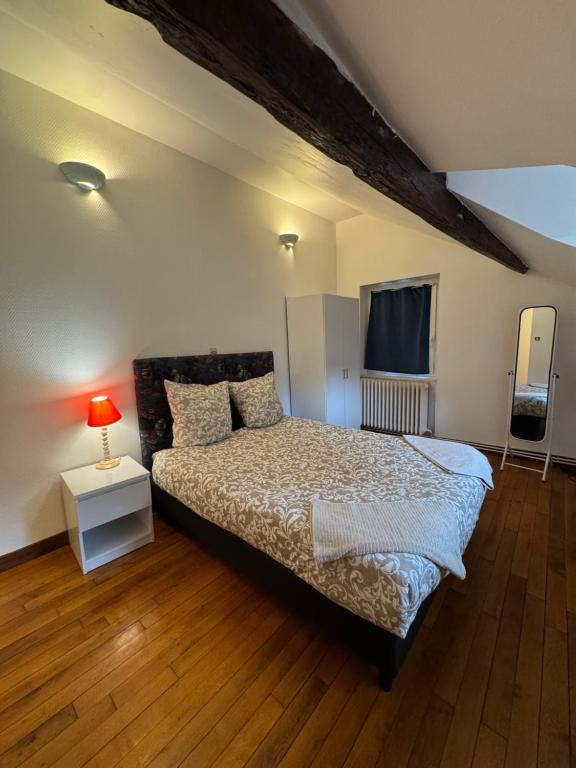 une chambre avec un lit et une table avec une lampe dans l'établissement Duplex République, à Orléans