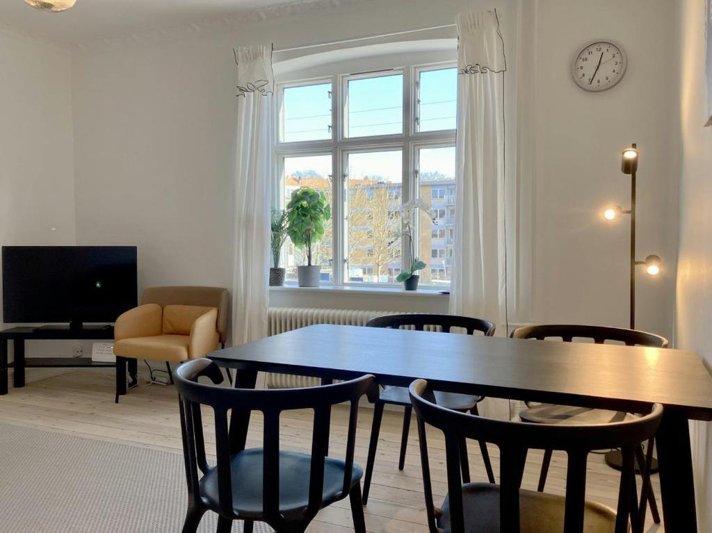 a dining room with a table and chairs and a window at Convenient Apartment for 2 in Randers