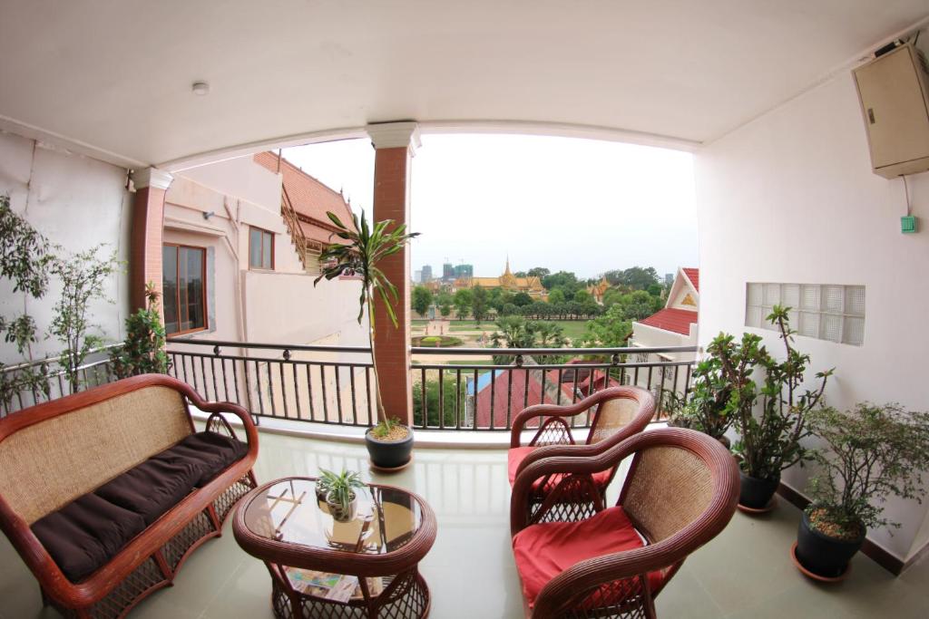 a balcony with chairs and a table and a window at RS Guesthouse in Phnom Penh