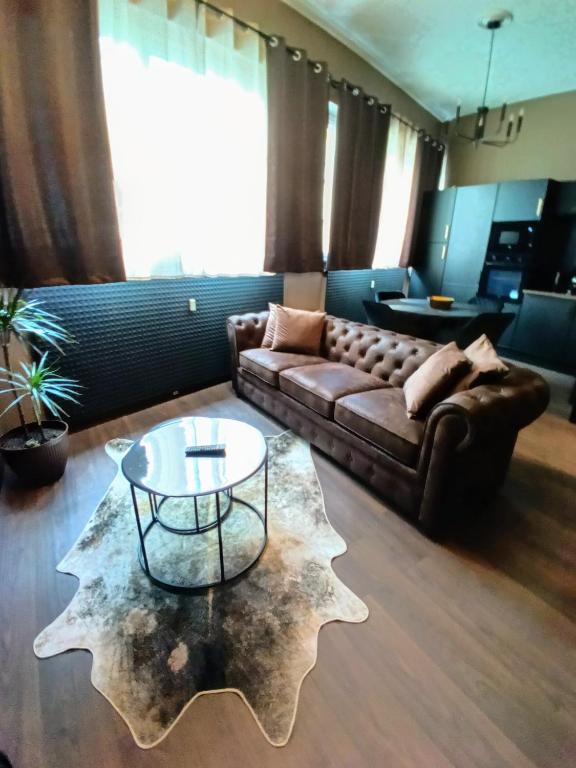 un salon avec un canapé et une table basse dans l'établissement Appart'Hôtel Le Phoenix, à Montbéliard