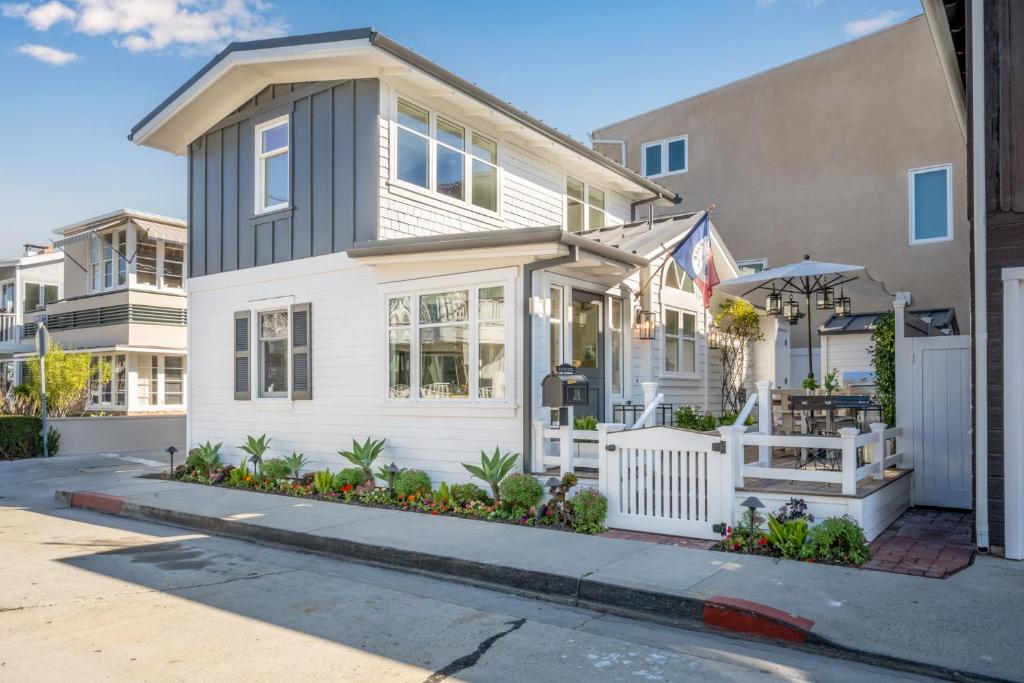 une maison blanche avec une clôture blanche devant elle dans l'établissement Balboa Island Gem with Patio & Beach Essentials, à Newport Beach
