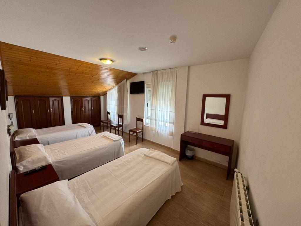 ein Krankenzimmer mit drei Betten und einem Tisch in der Unterkunft Hotel Luso-Porto de Leixoes in Bergondo
