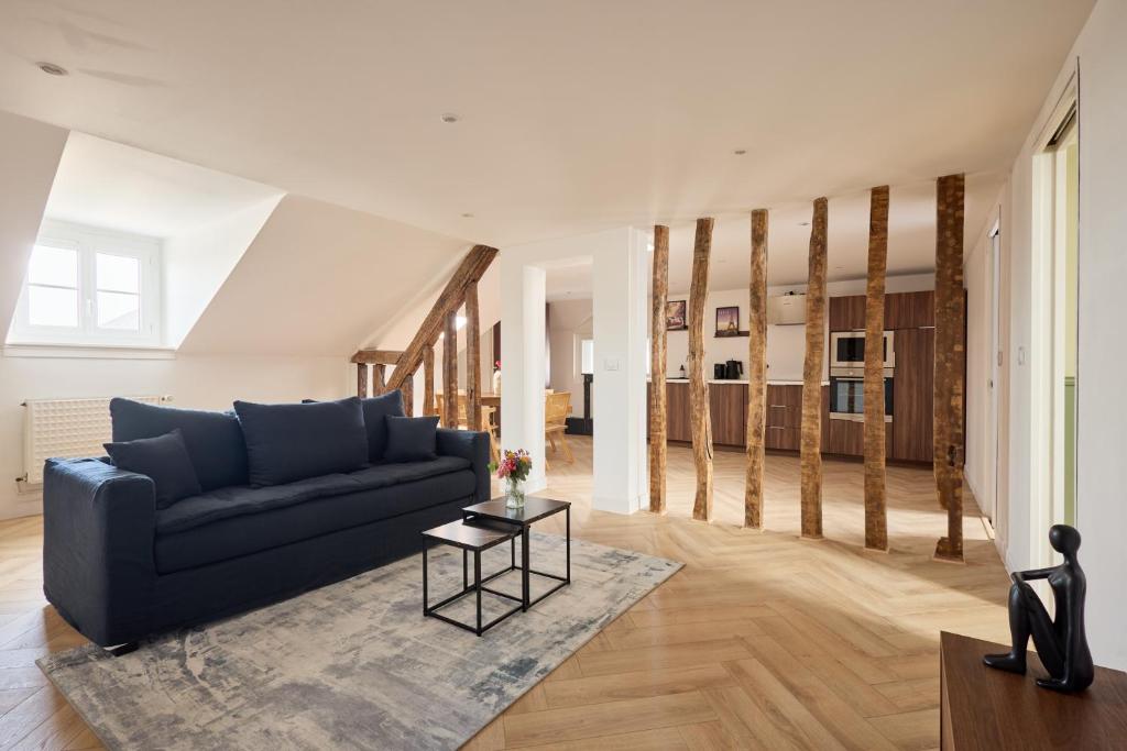 un salon avec un canapé bleu et une table dans l'établissement L Ecrin des Minimes, au Mans