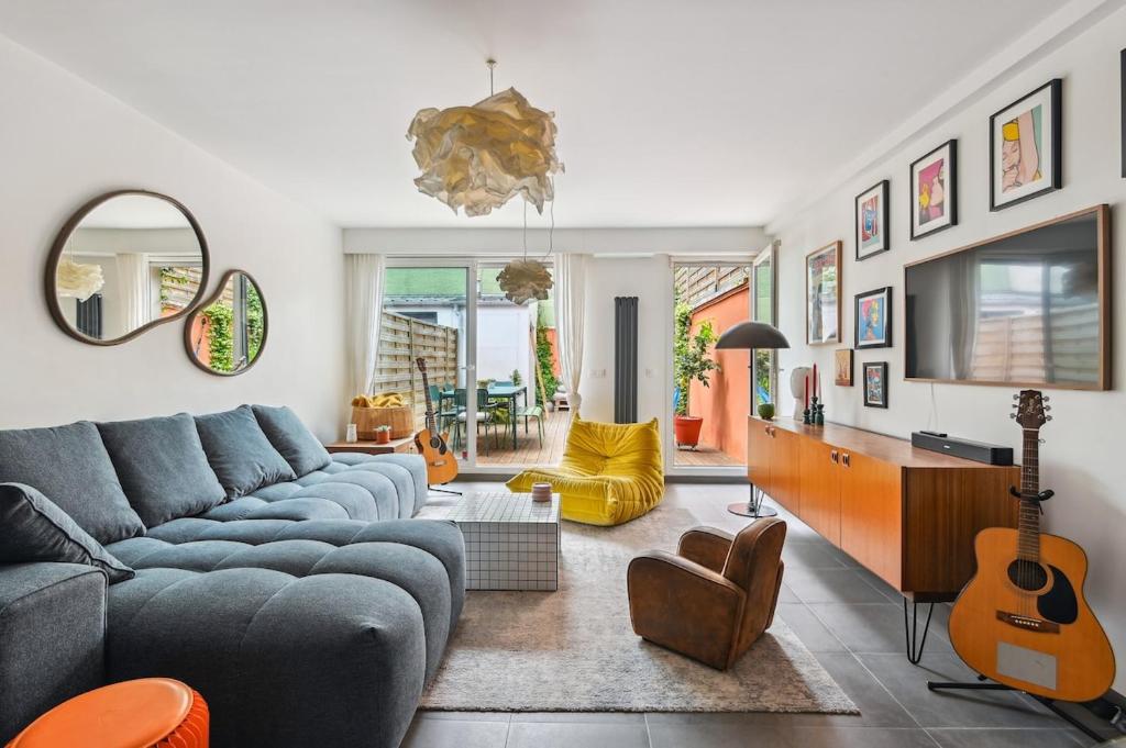 - un salon avec un canapé bleu et une guitare dans l'établissement Duplex design relaxing garden Porte de Paris, à Bagnolet