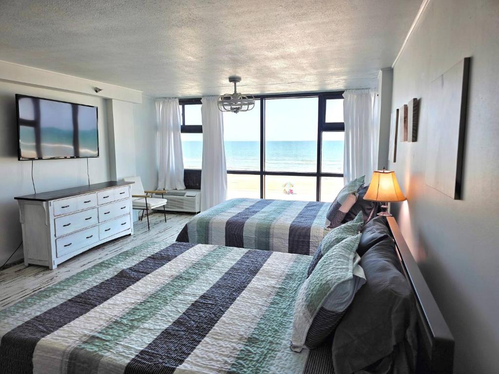 a bedroom with two beds and a view of the ocean at Fabulous Oceanfront Studio w/kitchen, tiki bar in Daytona Beach