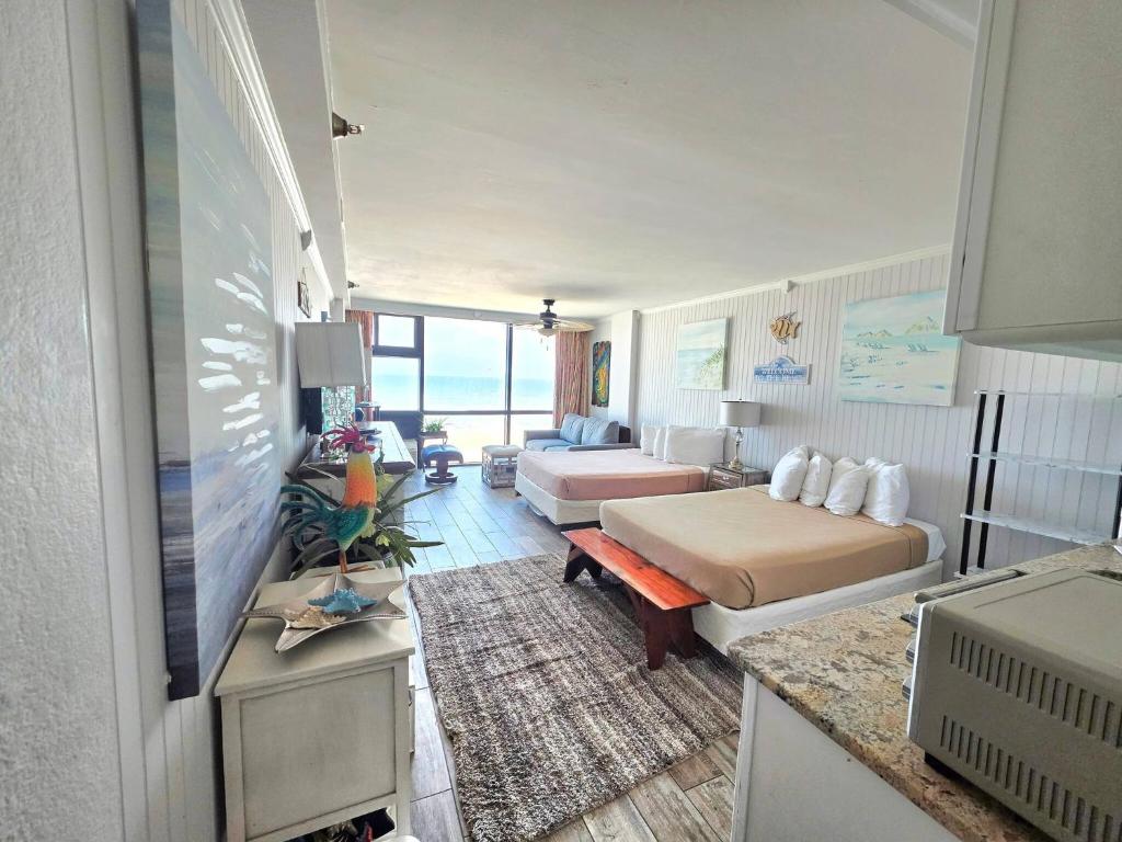 Un dormitorio con dos camas y una sala de estar. en Sunrise Oceanfront 2 Full Studio w/kitchen & pool, en Daytona Beach
