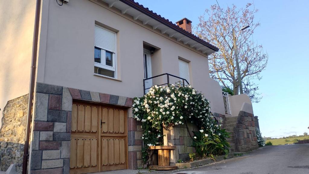 a white house with a wooden door with flowers on it at Villa Adelina in Heres