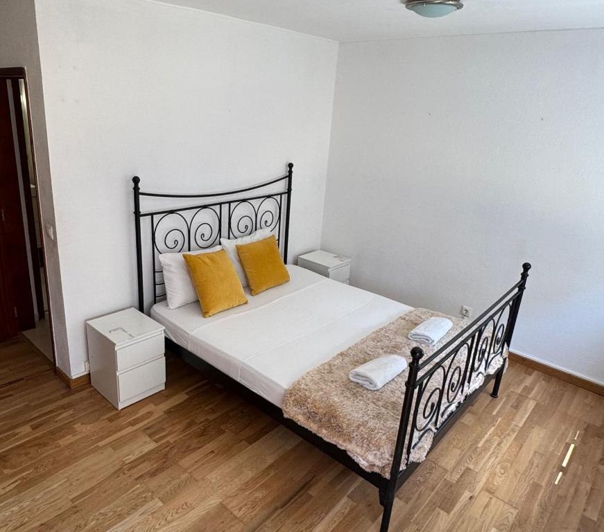 Hotel Apartment near airport, a bedroom with a black bed with yellow pillows at Apartment near airport in Lisbon