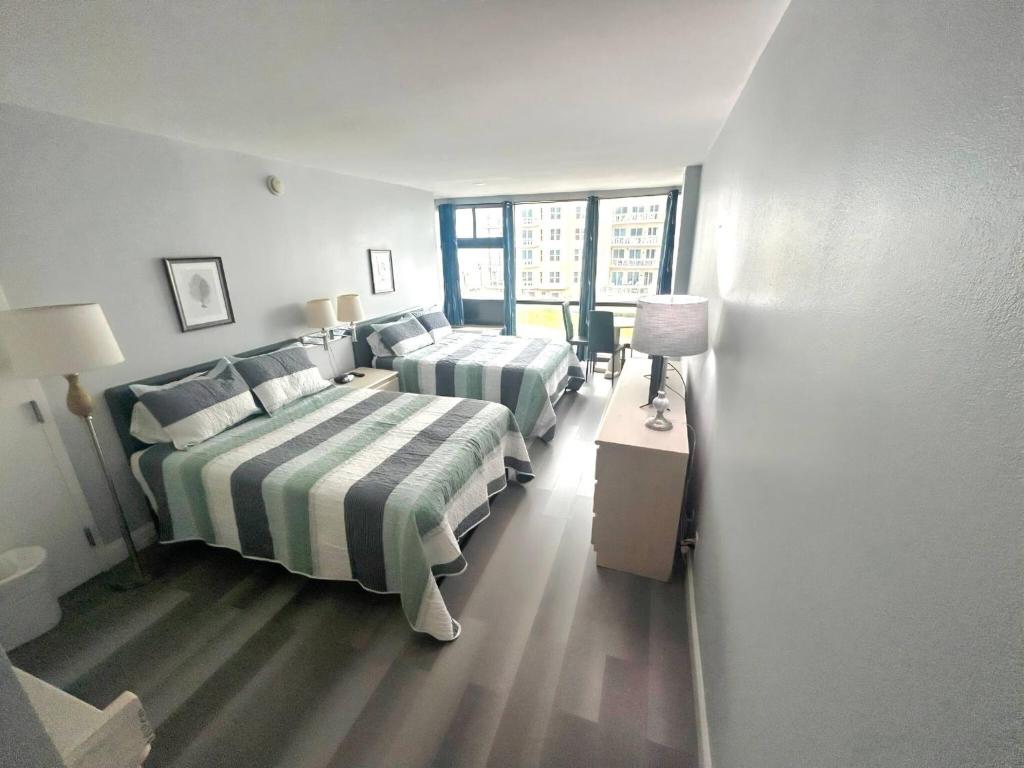 a hotel room with two beds and a window at Oceanview Studio w/kitchen, pool, tiki bar in Daytona Beach