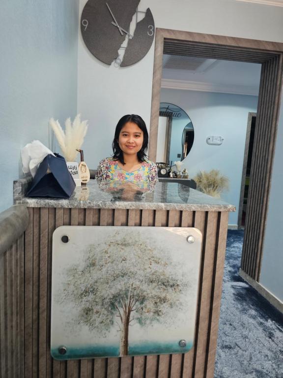 a woman standing in front of a counter with a mirror at Boutique residential units in Sabkhah