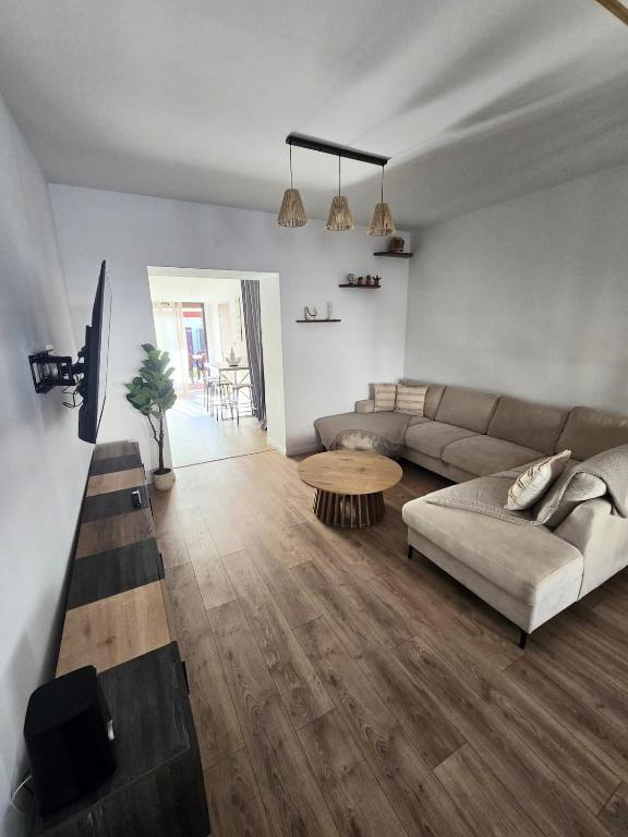 un soggiorno con un divano e un tavolo di Maison tout confort spacieuse a Flers-en-Escribeus