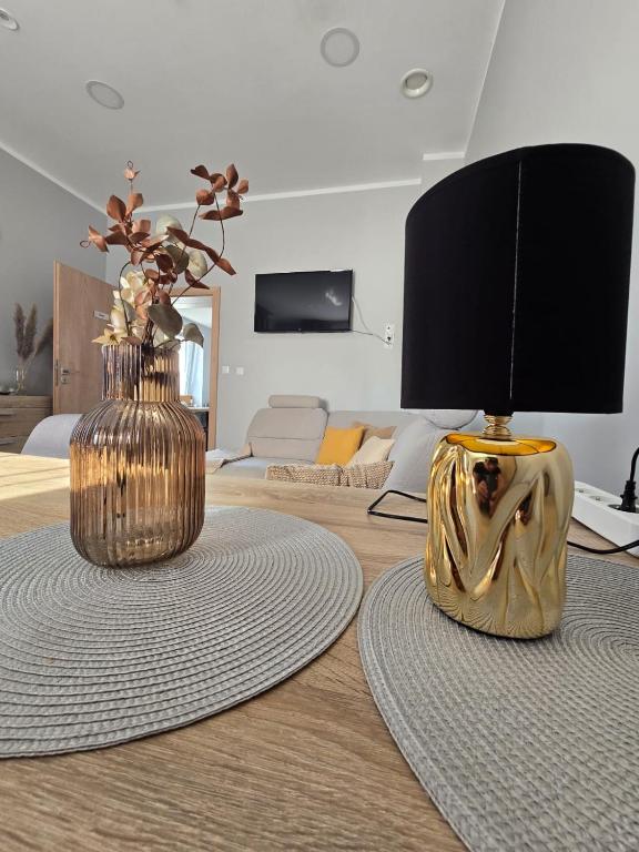 a living room with two vases and a lamp on a table at Welle DOLCE VITA in Grzybowo
