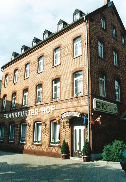 Un gran edificio de ladrillo rojo con un cartel. en Hotel Frankfurter Hof, en Limburg an der Lahn