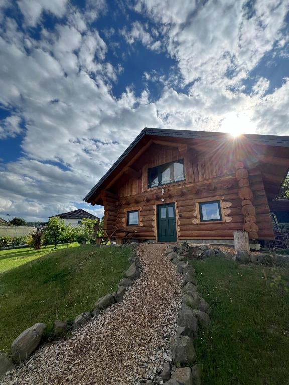 a log cabin with the sun shining on it at Holzhaus Wildsbergblick in Beiseförth