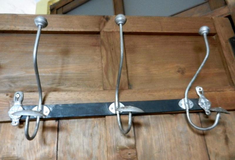 a group of hooks hanging from a wooden wall at LAS CUATRO CALLES Bis in Piedralaves