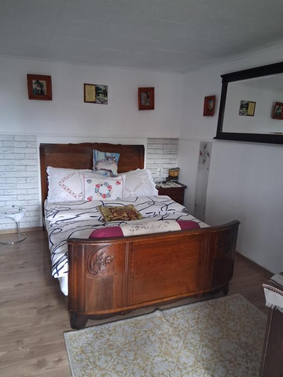 a bedroom with a wooden bed with a cat laying on it at Casa Denis rustic in Turda