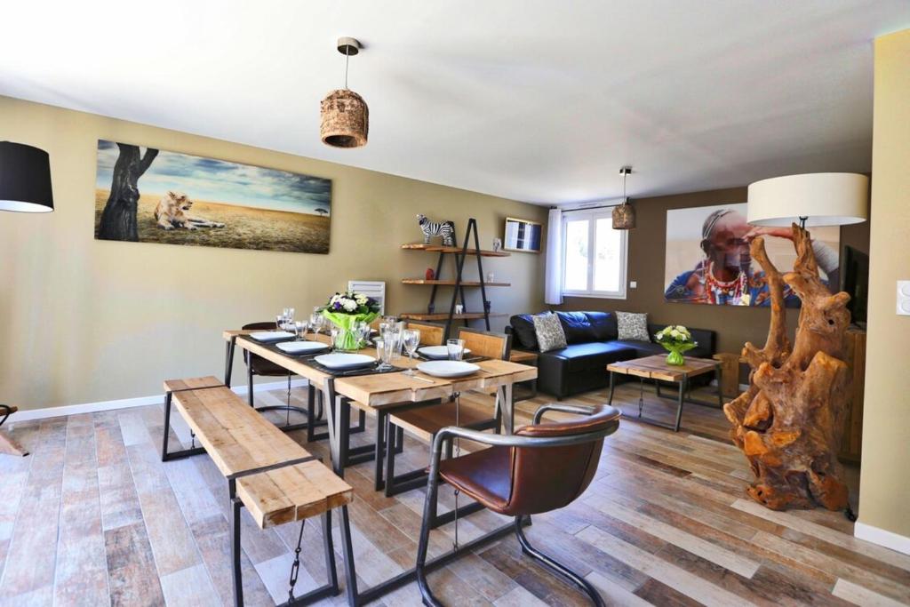 a living room with a dining room table and a couch at Villa Tanzanie - Domaine Le Sherwood in Notre-Dame-de-Monts
