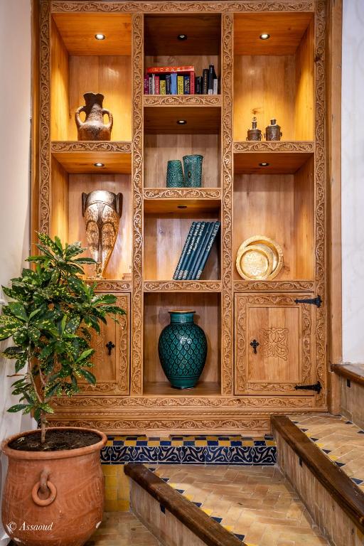 a wooden hutch with a potted plant in a room at Dar Bleumain in Chefchaouen