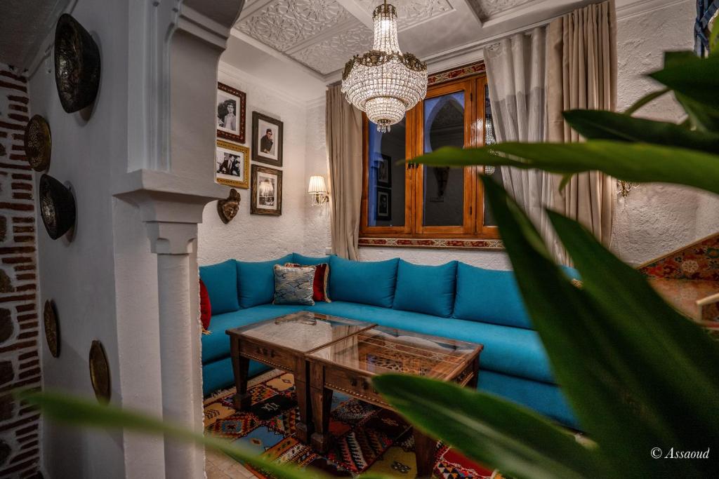 a living room with a blue couch and a table at Dar Bleumain in Chefchaouen