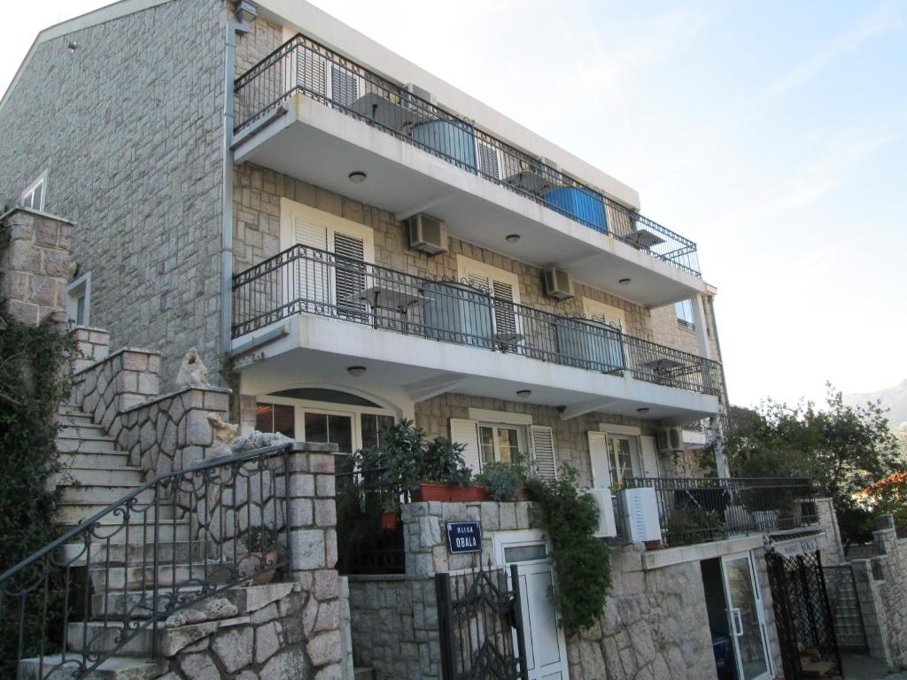 an apartment building with stairs and a balcony at Apartments Mitrovići Miločer in Sveti Stefan