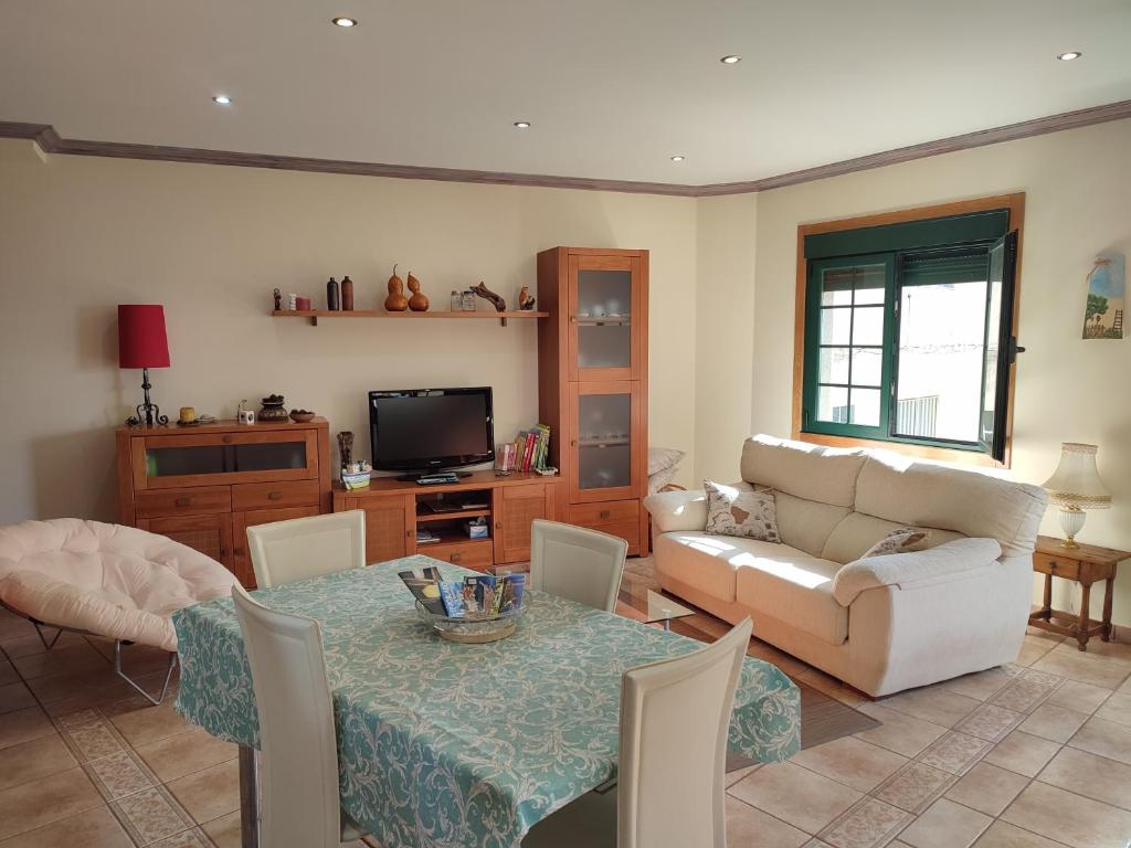 a living room with a table and a couch at Casa A RODA in Salcidos
