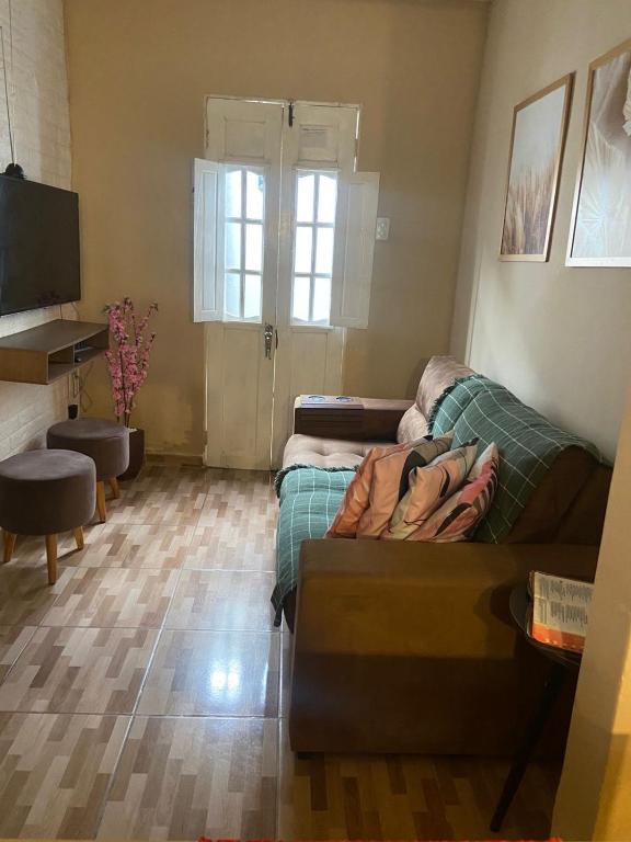 a living room with a couch and a television at Casa familiar perto da Escola São Cristovão in Garanhuns